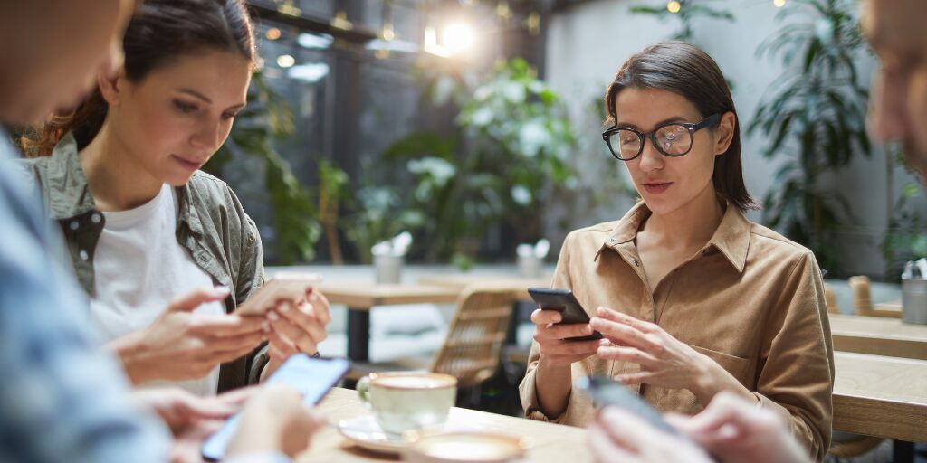 two women on their phones in a summer season to represent the importance of mobile-friendly websites.