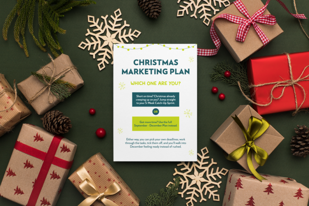 A copy of a Christmas marketing planner on a table with Christmas gifts and stars around it.